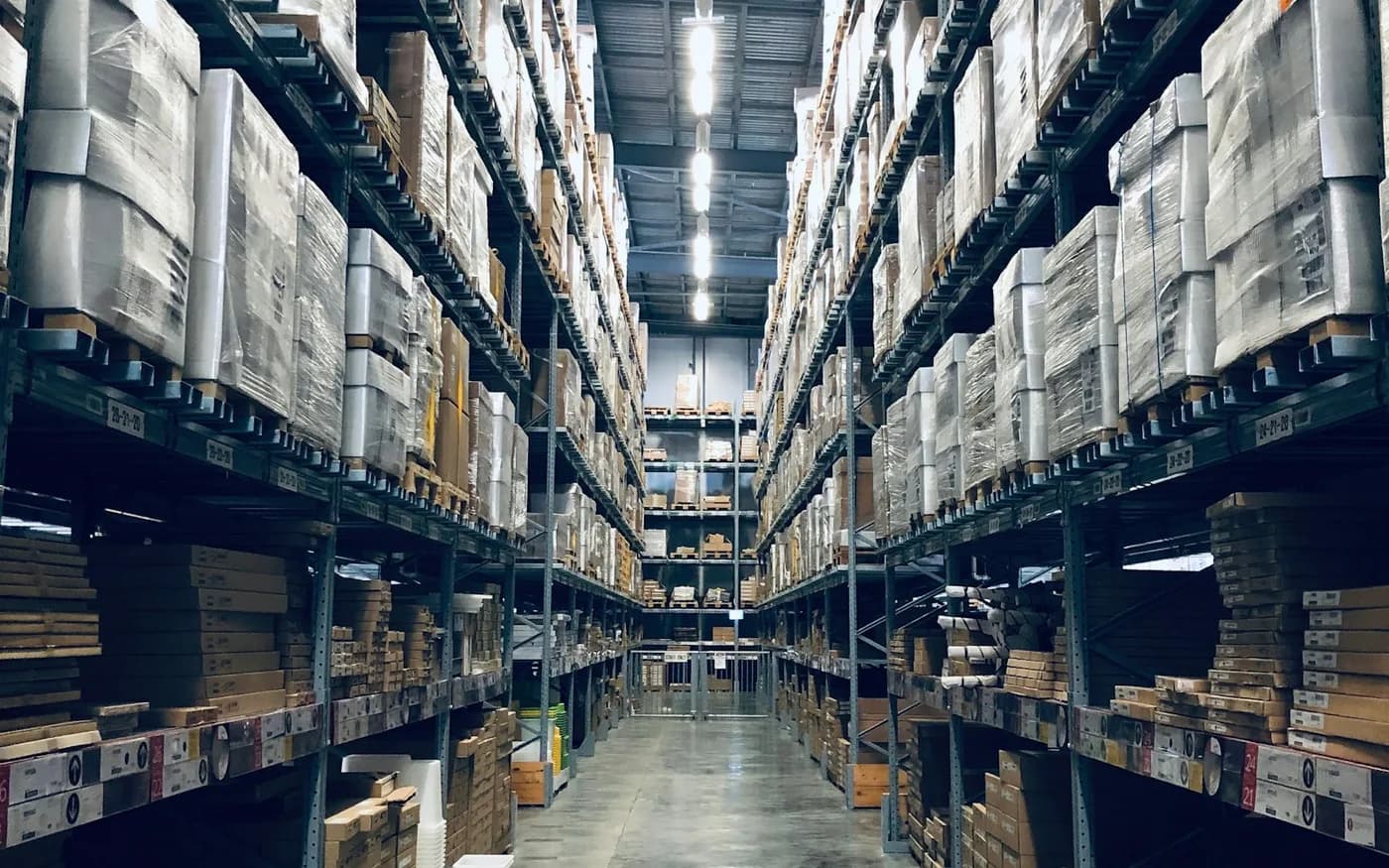 Estoque organizado em depósito com prateleiras e caixas